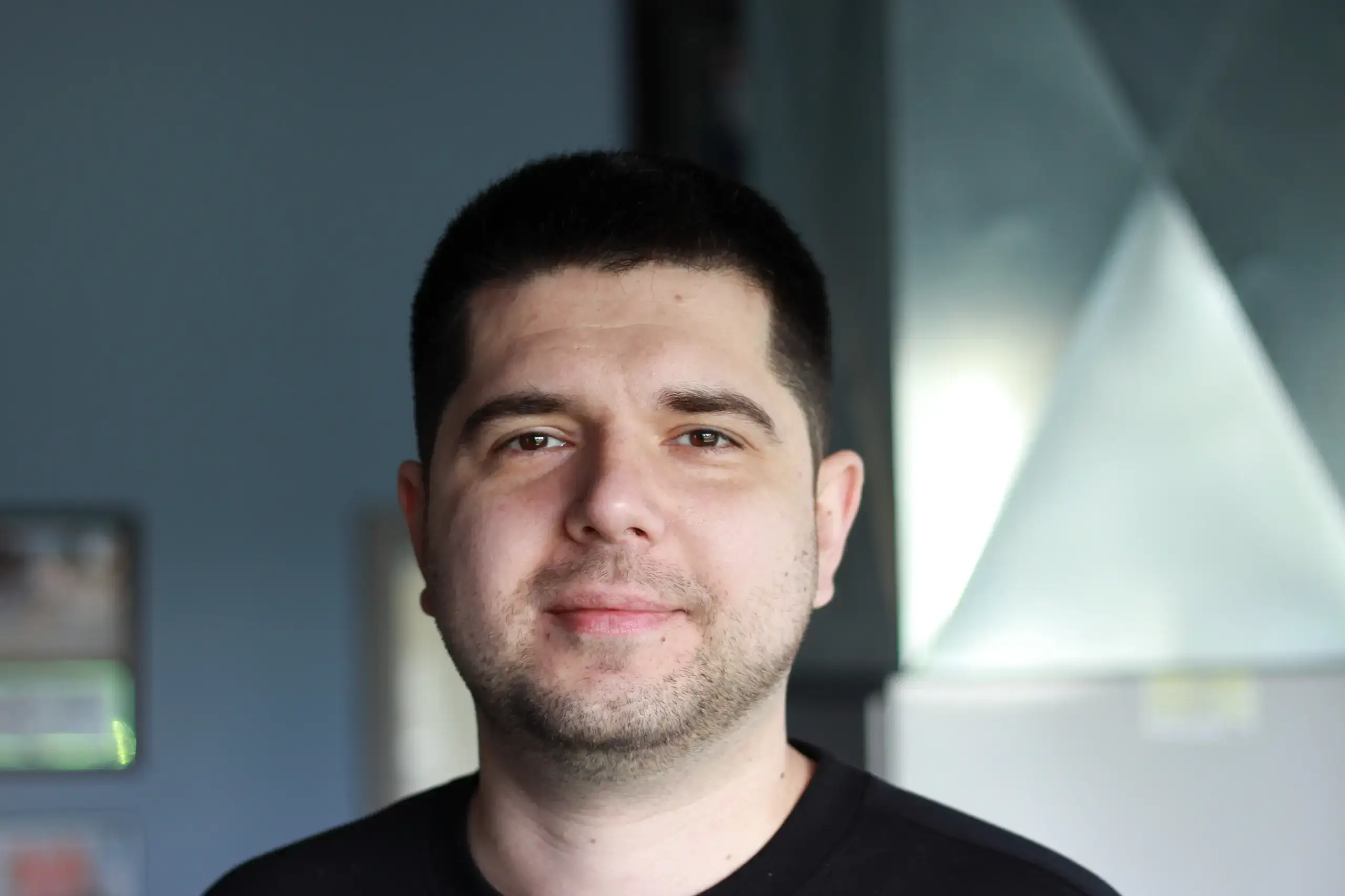 Headshot of Denis Bronat, an HVAC Mechanical Engineer specializing in commercial and residential building designs, smiling in a professional setting.