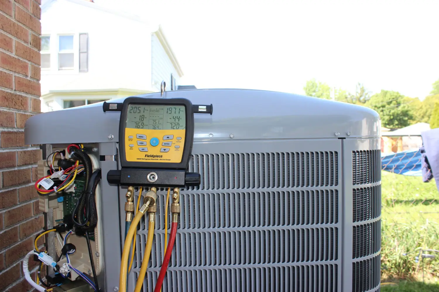 Professional AC Tune-Up & Maintenance Testing A Fieldpiece digital manifold gauge attached to an outdoor central air conditioning unit during an annual AC tune-up and maintenance check by K Komfort in Milwaukee, Wisconsin.