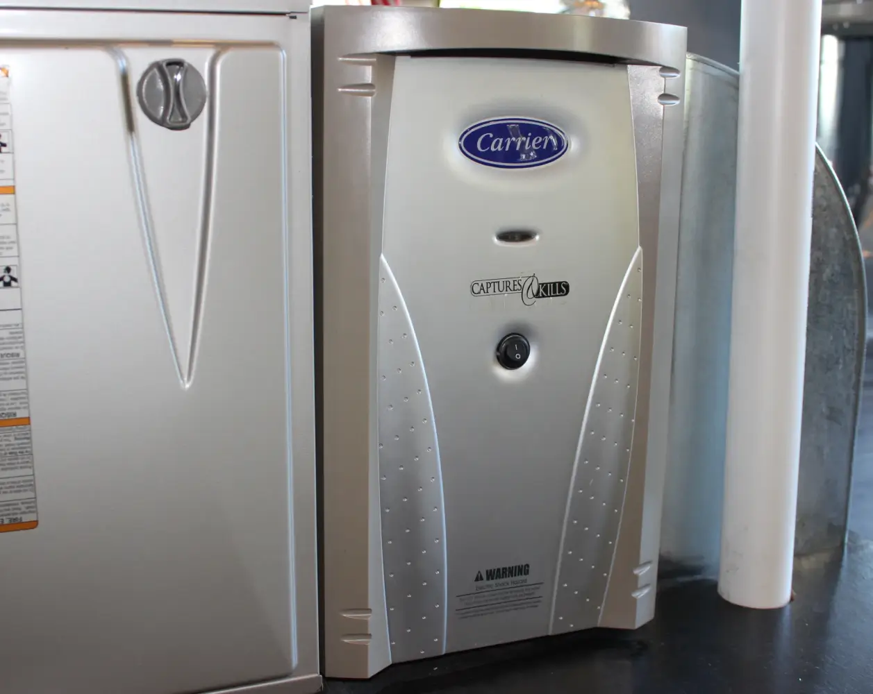 Carrier Whole-House Dehumidifier Installation A premium Carrier whole-home dehumidifier unit installed alongside a residential HVAC furnace system by K Komfort.