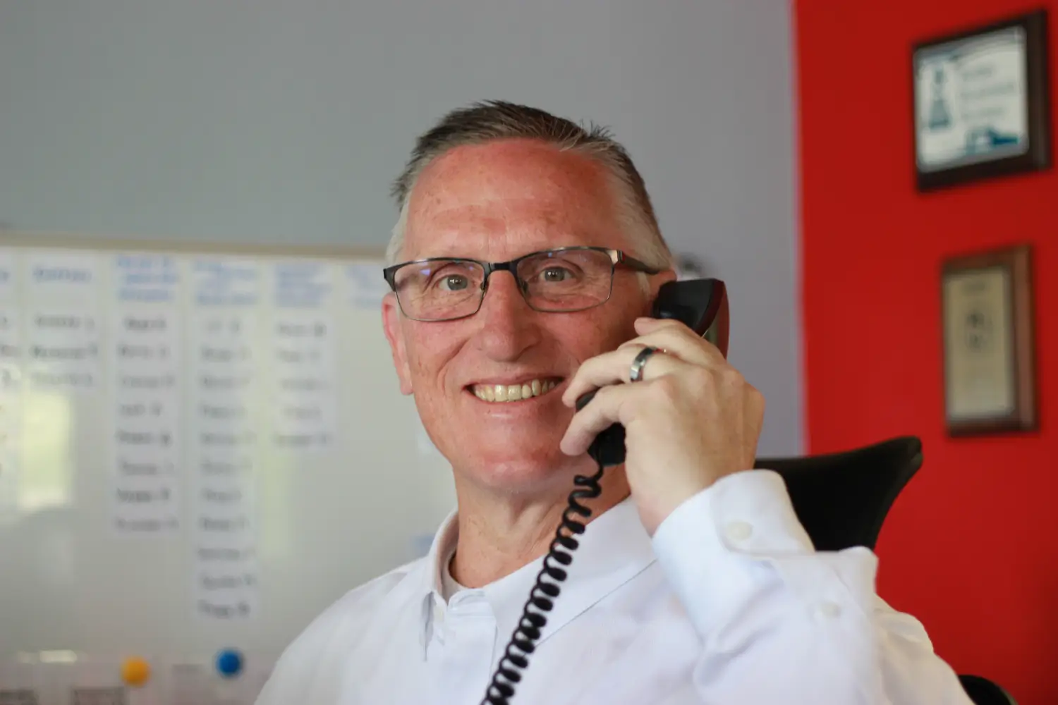 Doug Arendt, K Komfort Customer Service Representative & Dispatcher, on an emergency HVAC service call phone in Milwaukee office.