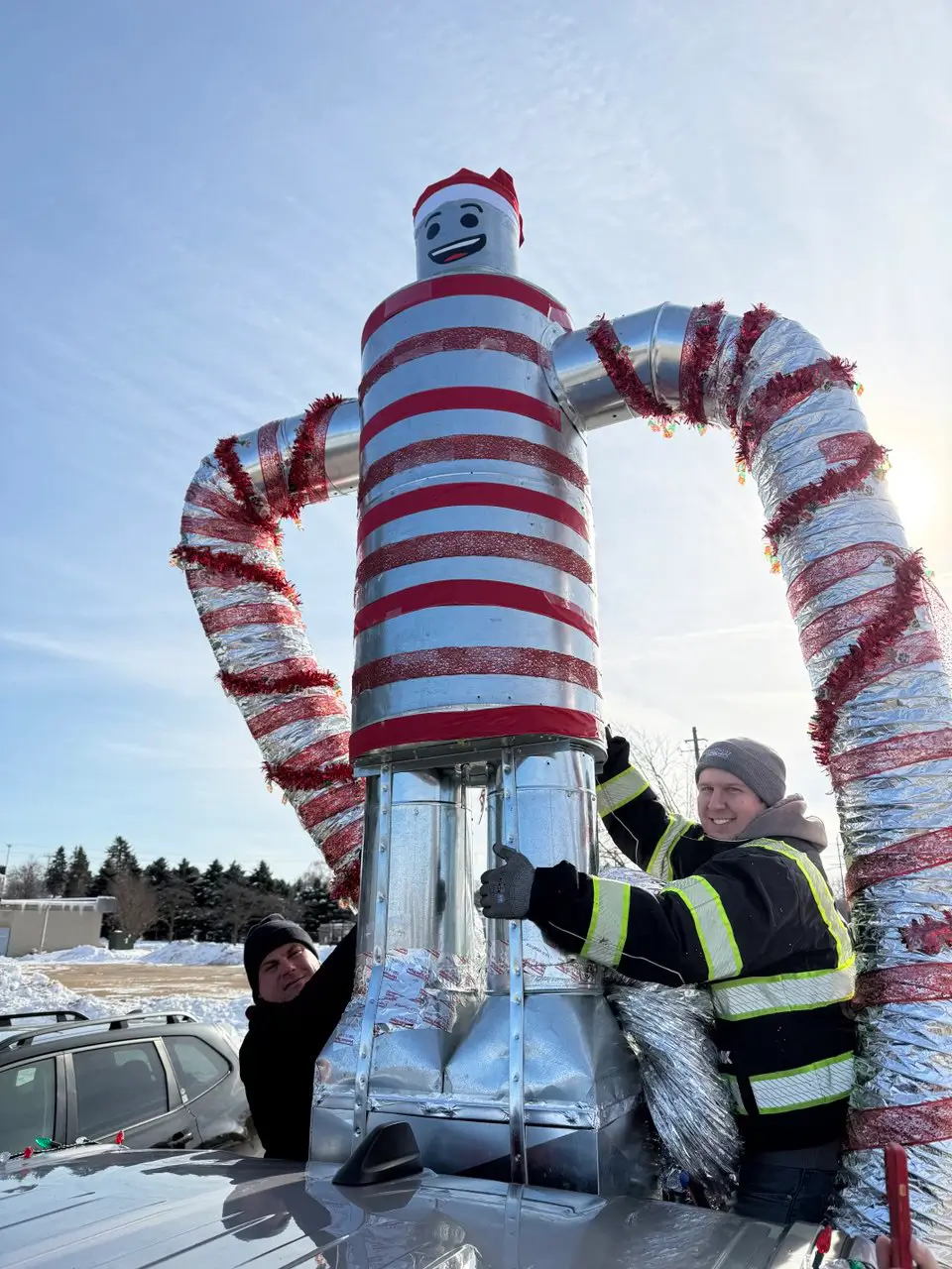 K Komfort Heating and Cooling team members with their custom HVAC sheet metal mascot at the Grafton Christmas parade in Southeast Wisconsin.