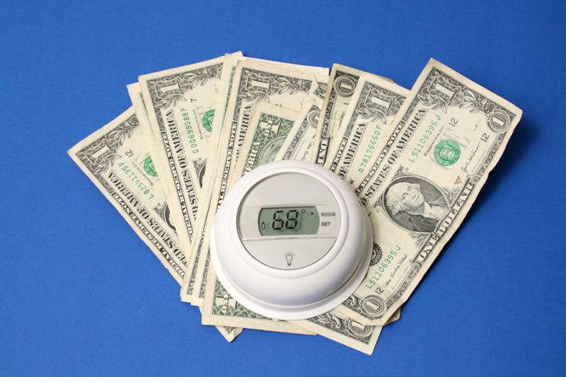 Image of a thermostat and about 9 dollars. Spring Money-Saving Tips.