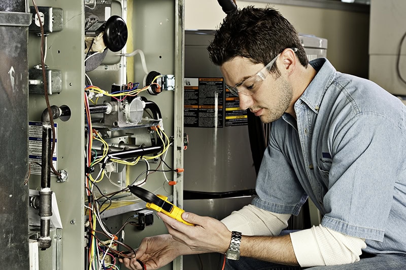 5 Reasons Why Regular HVAC Maintenance is Essential for Homeowners. Service technician testing an air conditioner.